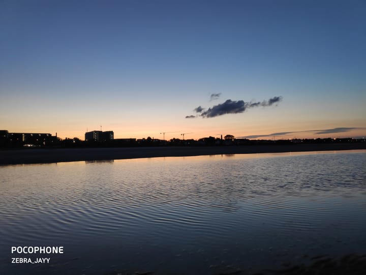 Water reflecting a skyline at dusk